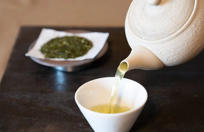 急須から湯呑みに緑茶を注いでいる様子